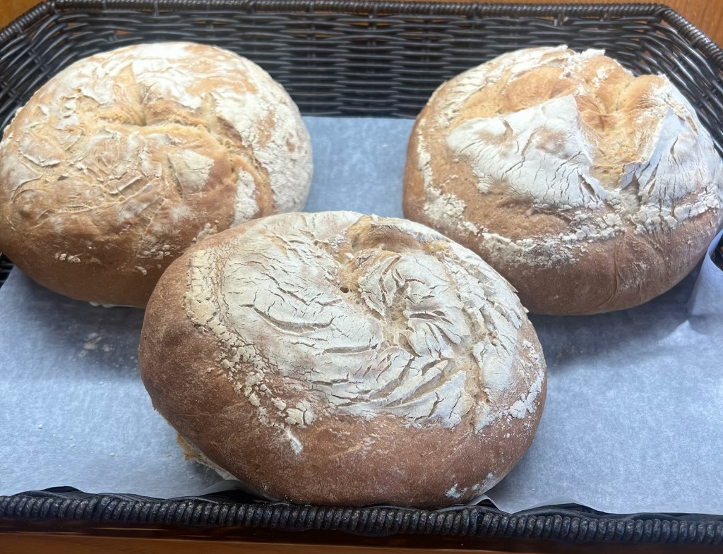 Freshly baked round artisan bread loaves in a basket